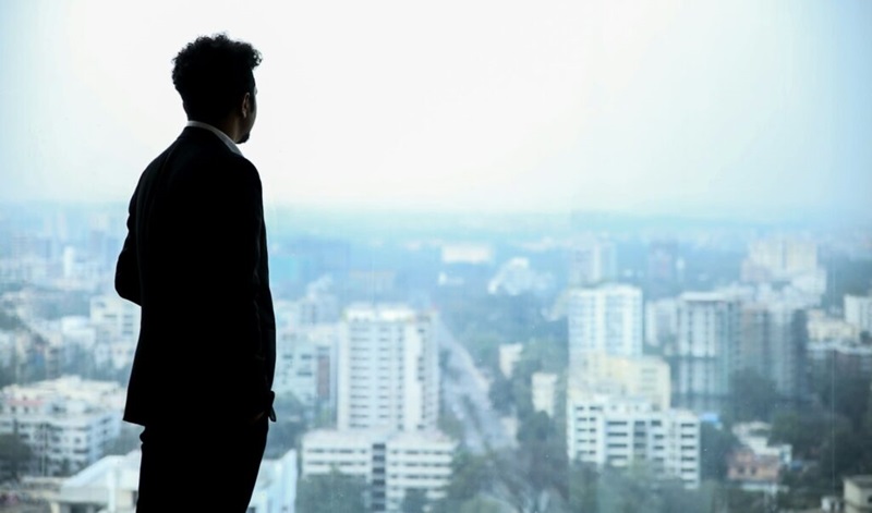 転職理由を思いあぐねて立ち尽くす男性の画像