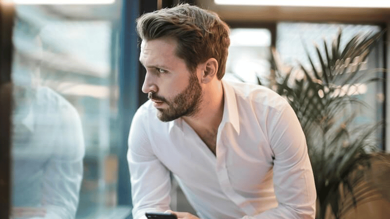 不安そうに窓の外を眺める男性