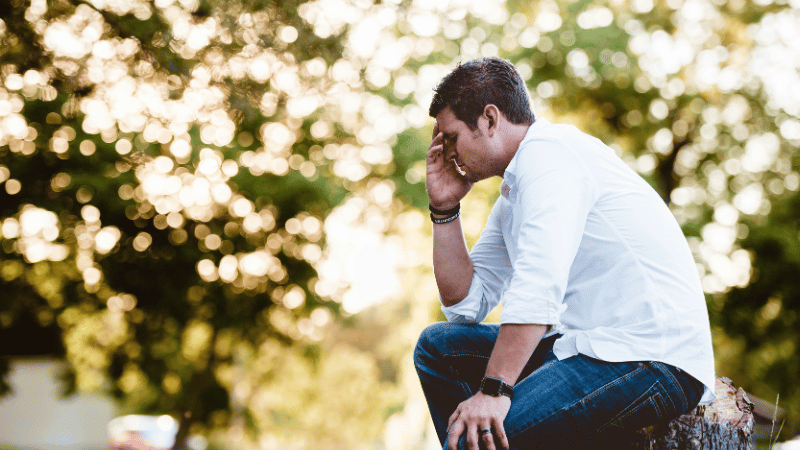 仕事を辞めるか続けるか悩む男性の画像