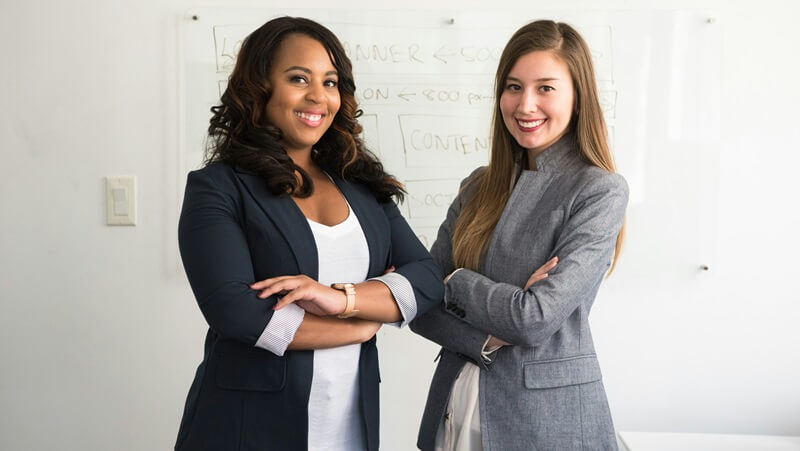 笑顔で腕組みをしている女性2人