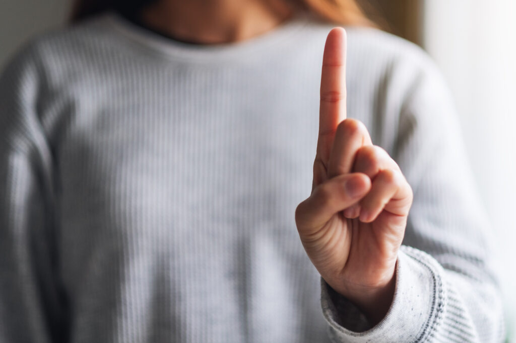 人差し指を立てている女性