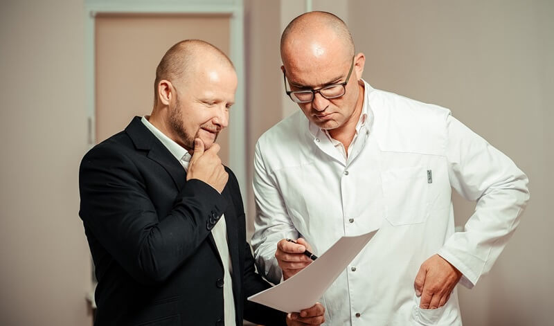 資料を見ながら話し合う男性2人