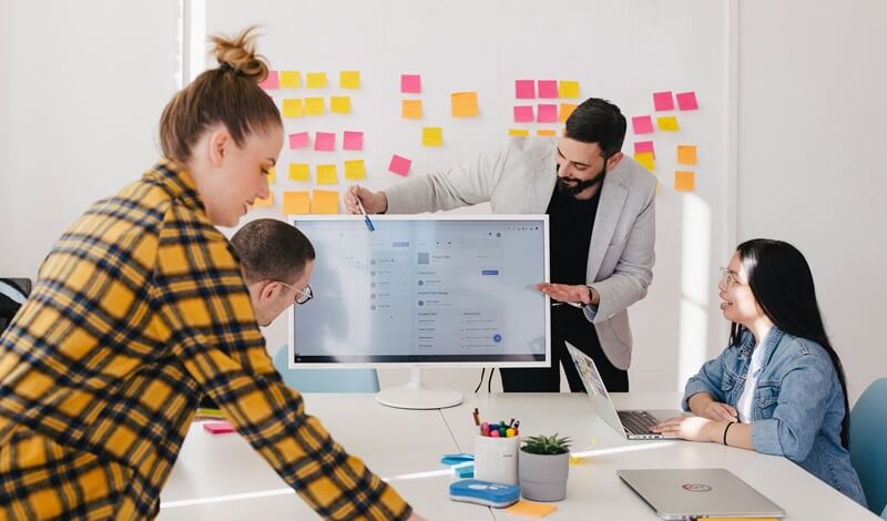 モニターを使って会議で説明している男性