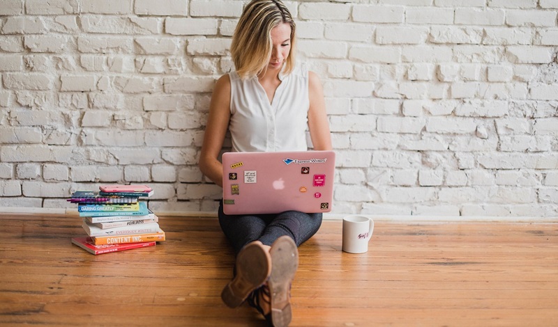 ピンクのパソコンを操作している女性