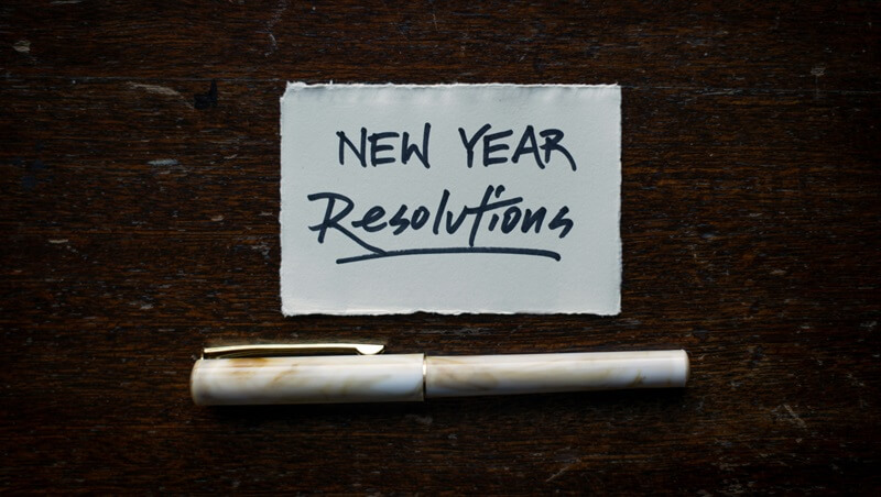 NEW YEAR Resolvtionsと書かれた紙とペン