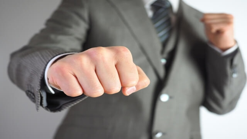 ストレスに立ち向かう決心をし拳を握るビジネスパーソン
