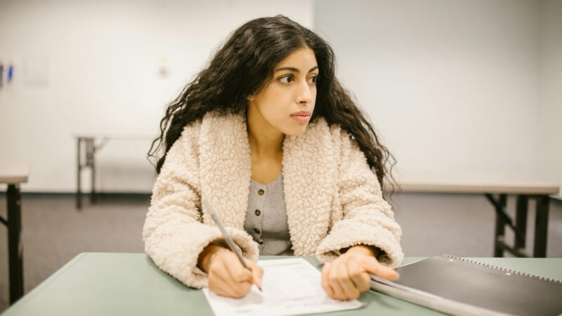 席についてノートを取る女性