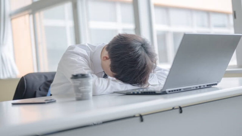 仕事だけの人生に心身の疲労がたまり机に突っ伏す男性