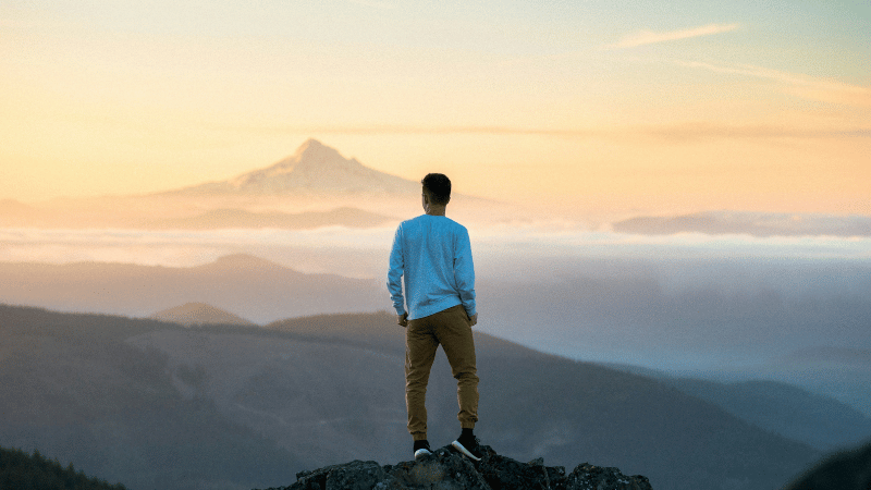 山の頂に立つ男性