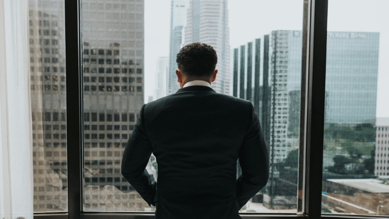 窓の前にたたずむ男性