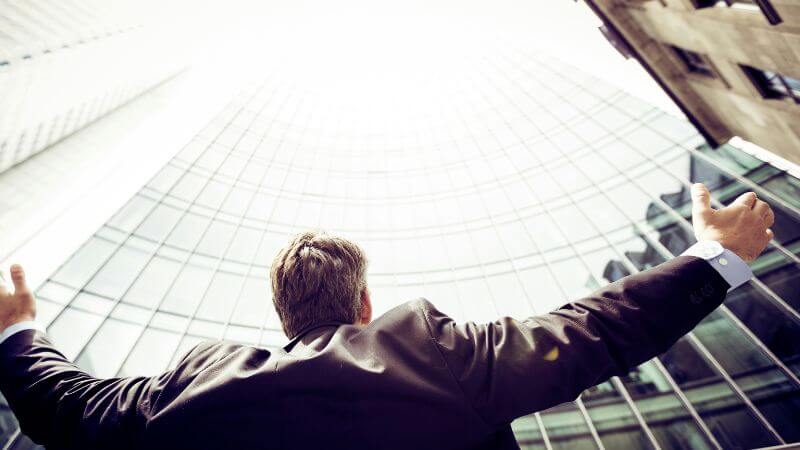 両手を広げ空を見上げる男性