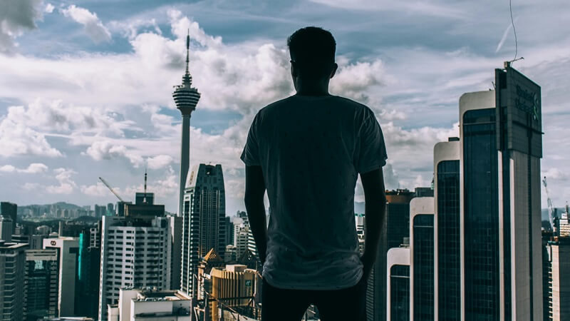 ビル街を見下ろす男性