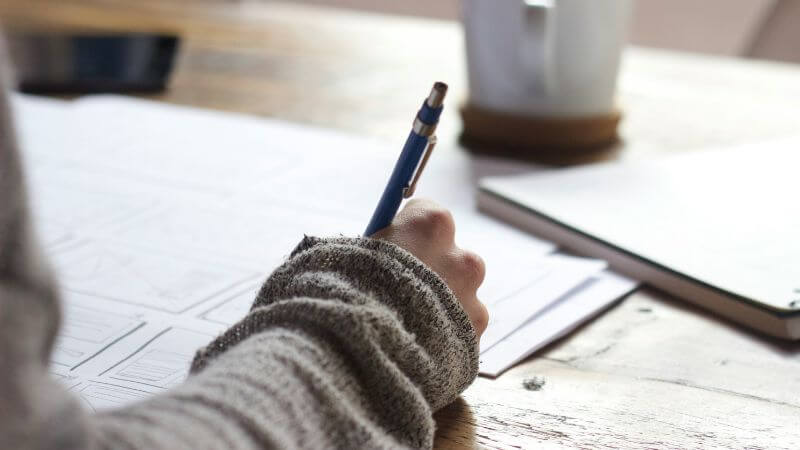 紙とペンを持つ手