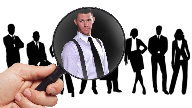 虫眼鏡で男性を見る