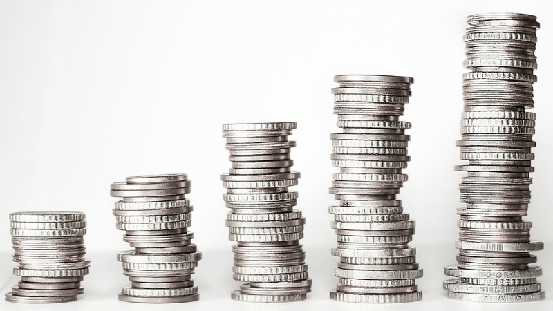 右肩上がりで積み上がっているコインの山