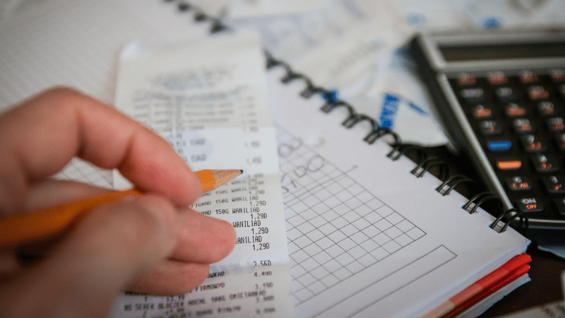 家計簿をつけている手