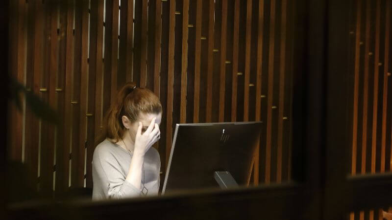 パソコンの前で頭を抱える女性